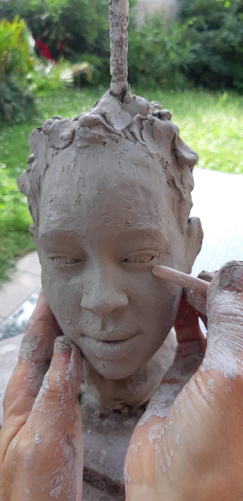 Modelage d'un visage en cours en argile